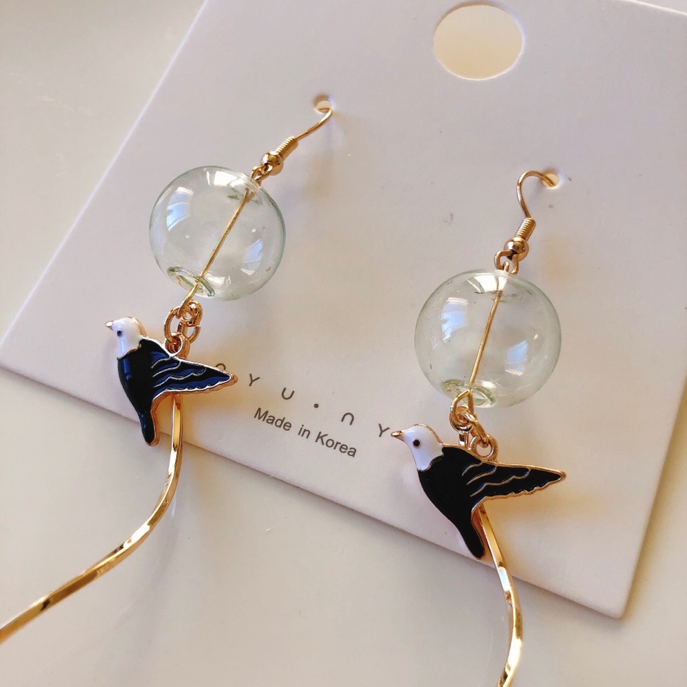 Glass ball and bird dangle earrings
